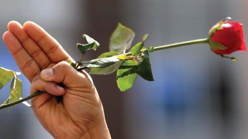 epa09711490 (14/31) (FILE) - A person holds a rose and flashes the defiant three-finger salute ...