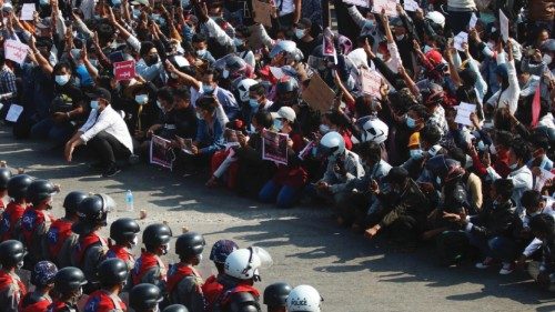 epa09711488 (12/31) (FILE) - Riot police stand guard as demonstrators flash the three-finger salute, ...