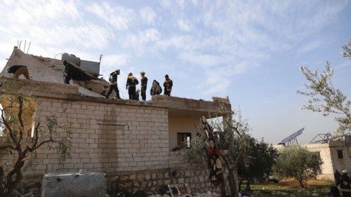 Emergency personnel work amid debris on a building destroyed in the aftermath of a counter-terrorism ...