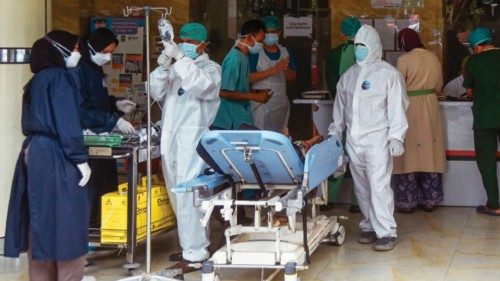 Medical personnel examine a new patient on the terrace of a public hospital near Bekasi, east of ...