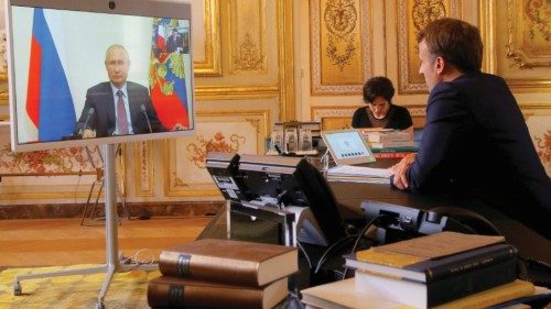 FILE PHOTO: French President Emmanuel Macron talks with Russian President Vladimir Putin during a ...