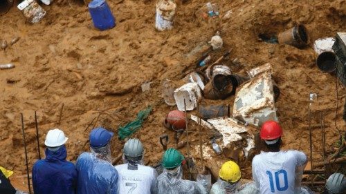 Volunteers wait for their turn to look for victims of a landslide after heavy rain in Franco da ...