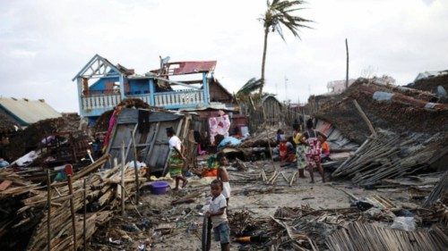 Locals stand among destroyed houses, in the aftermath of Cyclone Batsirai, in Mananjary, Madagascar, ...
