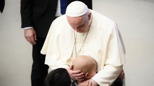 Pope Francis hugs a sick child after the general audience in the Paul VI Hall at the Vatican on ...