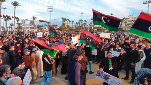 Libyans lift placards and national flags during a demonstration against the House of Representatives ...