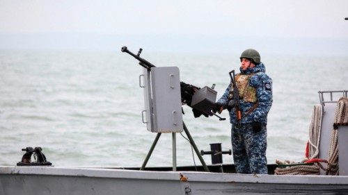 A serviceman stays in guard as he boat patrols water area of Ukraine's Black Sea port of Mariupol on ...