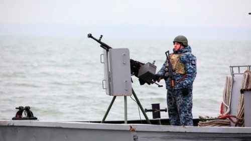 A serviceman stays in guard as he boat patrols water area of Ukraine's Black Sea port of Mariupol on ... A serviceman stays in guard as he boat patrols water area of Ukraine's Black Sea port of Mariupol on ...