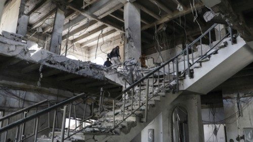 A security guard and workers inspect damage in a building hit by Saudi-led air strike at a ...
