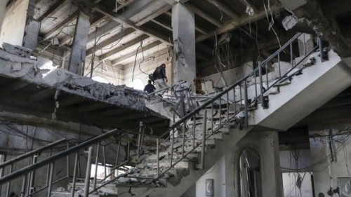 A security guard and workers inspect damage in a building hit by Saudi-led air strike at a ... A security guard and workers inspect damage in a building hit by Saudi-led air strike at a ...