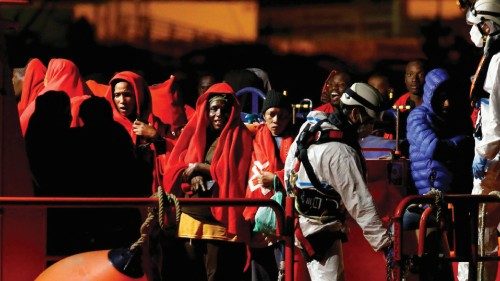 Migrants wait to disembark from a Spanish coast guard vessel, in the port of Arguineguin, in the ...