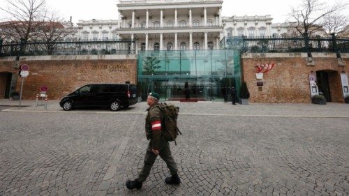 FILE PHOTO: A member of Austrian armed forces walks past Palais Coburg, the site of a meeting of the ...