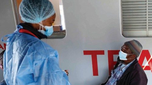 An elderly man questions a healthcare worker about the different vaccines available for them outside ...