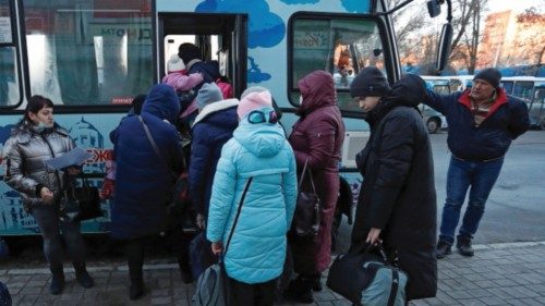People board a bus during the evacuation of local residents to Russia, in the rebel-controlled city ...