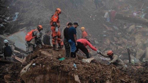 TOPSHOT - Rescuers worker at the scene of a giant landslide in Petropolis, Brazil on February 18, ...