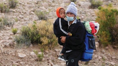 A Venezuelan migrant walks with a child after crossing the border in the highlands between Bolivia ...