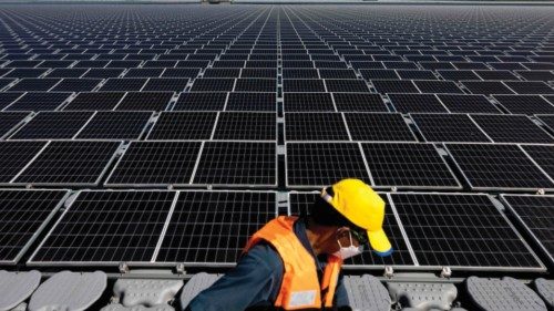 A worker walks past floating solar panels for the Sirindhorn Dam hydro-solar farm run by the ...