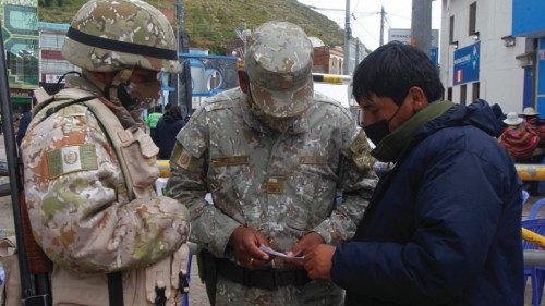 Soldiers check the documents of a man at the Peruvian border with Bolivia in the village of ...