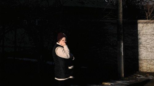 A woman stands in a street as black smoke rises from a military airport in Chuguyev near Kharkiv on ... A woman stands in a street as black smoke rises from a military airport in Chuguyev near Kharkiv on ...