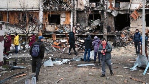 People gather in front of a damaged residential building at Koshytsa Street, a suburb of the ...