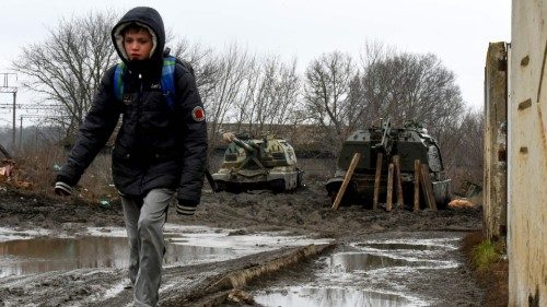 A boy walks in front of Russian armored vehicles parked at a railway station in the southern Russian ...