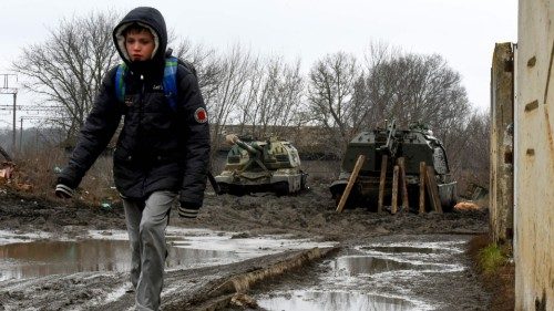 A boy walks in front of Russian armored vehicles parked at a railway station in the southern Russian ... A boy walks in front of Russian armored vehicles parked at a railway station in the southern Russian ...