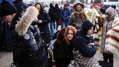 People wait outside a temporary accommodation centre after fleeing Russian invasion of Ukraine, in ...