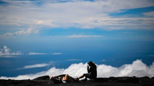 Visitors rest at the summit of the Piton de la Fournaise volcano in the heights of Saint-Benoit on ...