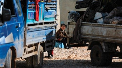 An internally displaced Syrian child sits among trucks loaded with peosonal belongings at a camp, ... An internally displaced Syrian child sits among trucks loaded with peosonal belongings at a camp, ...