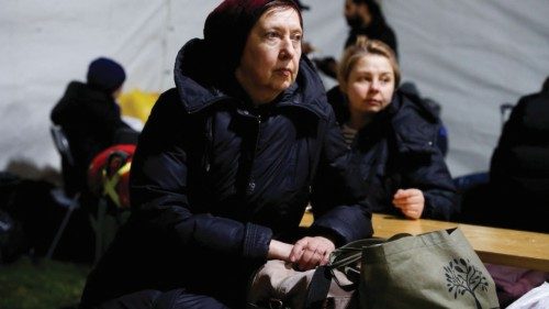 A woman fleeing Russia's invasion of Ukraine sits at a temporary shelter outside the train station ...