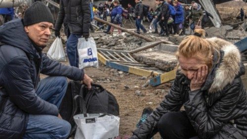 epa09807248 A woman reacts as she sits next to a woman lyiing on the ground after crossing the ... epa09807248 A woman reacts as she sits next to a woman lyiing on the ground after crossing the ...