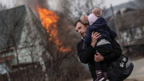 A man and a child escape from the town of Irpin, after heavy shelling on the only escape route used ...