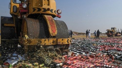 An official uses a steamroller to crush seized bottles of liquor, previously smuggled into the ...