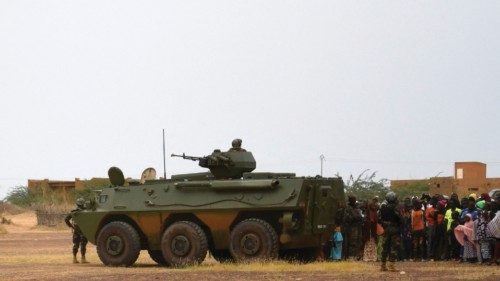 An armoured personnel carrier takes position as Niger's President Mohamed Bazoum addresses a crowd ...