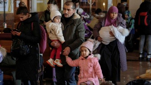 epa09817797 People with children wait for the train in the railway station as they try to flee the ...