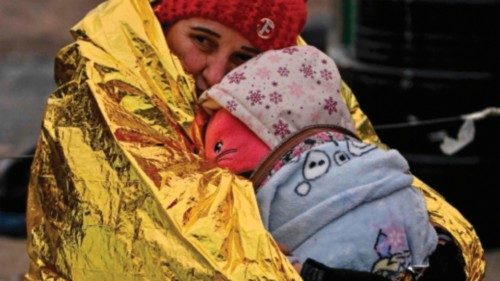 A woman hugs her grandaugther as people wait in freezing cold temperatures to be transferred to a ...