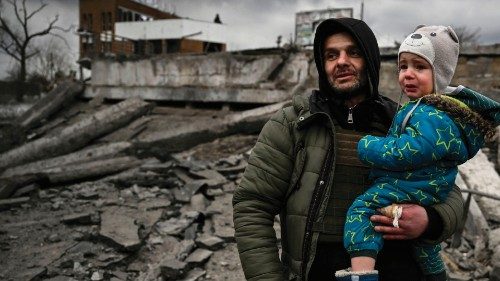 TOPSHOT - A man holds a child as he flees the city of Irpin, west of Kyiv, on March 7, 2022. - ...