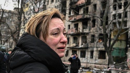EDITORS NOTE: Graphic content / TOPSHOT - A woman reacts as she stands outside destroyed apartment ...