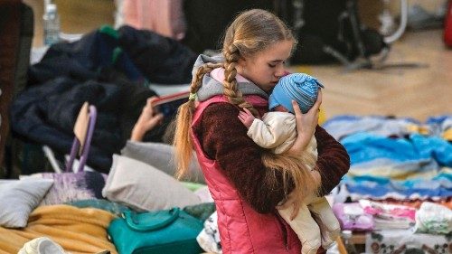 TOPSHOT - A girl holds her sibling in a temporary shelter for Ukrainian refugees in a school in ...