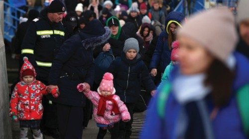 A woman walks with two kids, as they arrive by ferry after fleeing from Russia's invasion of ...