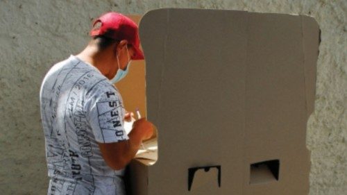 A person prepares a ballot at a booth during congressional and presidential coalitions elections ...