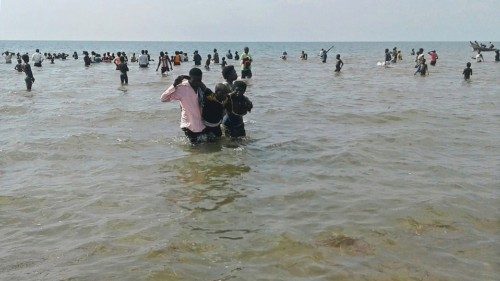 People help a man to come ashore from Lake Albert, on December 26, 2016 in Buliisa, after at least ...