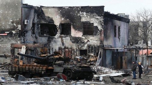 Local residents are seen next to a destroyed armoured vehicle during Ukraine-Russia conflict in the ... Local residents are seen next to a destroyed armoured vehicle during Ukraine-Russia conflict in the ...