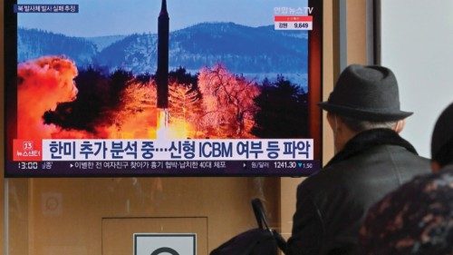 People watch a television screen showing a news broadcast with file footage of a North Korean ...