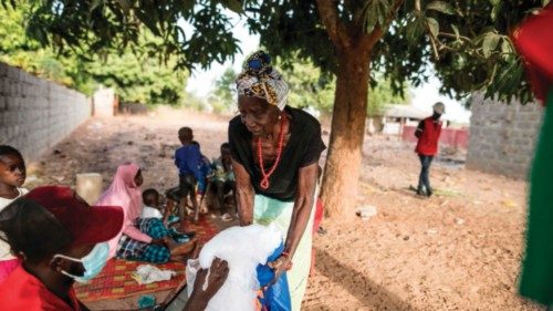 A member of the Gambian Red Cross gives emergency supplies to an internally displaced woman in the ...