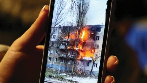 Irina from Mykolaiv shows a picture of a friend's burning apartment on her mobile phone, while ...