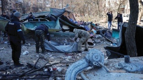 Rescue workers move the body of a person who was killed when a shell hit a residential building, as ... Rescue workers move the body of a person who was killed when a shell hit a residential building, as ...