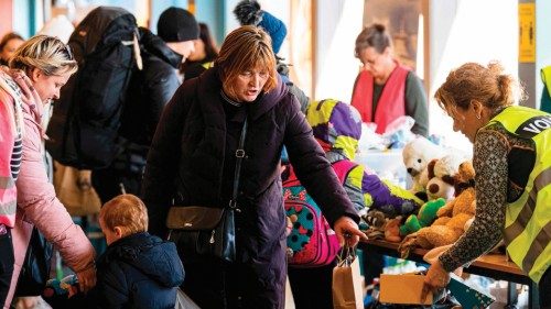 Volunteers distribute supply articles and information to Ukrainian refugees upon their arrival at a ...