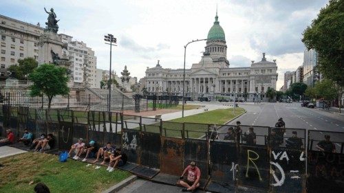 TOPSHOT - Police officers guard behind a fence the Argentine Congress while senators discuss the ... TOPSHOT - Police officers guard behind a fence the Argentine Congress while senators discuss the ...