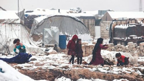 Children play in the snow at a camp for internally displaced Syrians, near the town of Kafr Lusin, ...