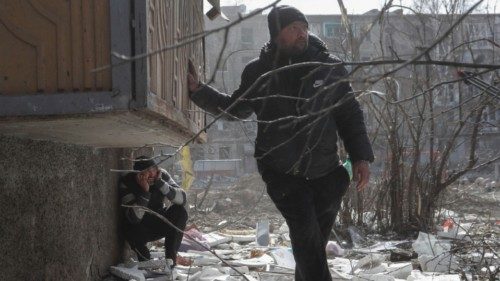 Local residents take cover as they hear blasts during Ukraine-Russia conflict in the besieged ...